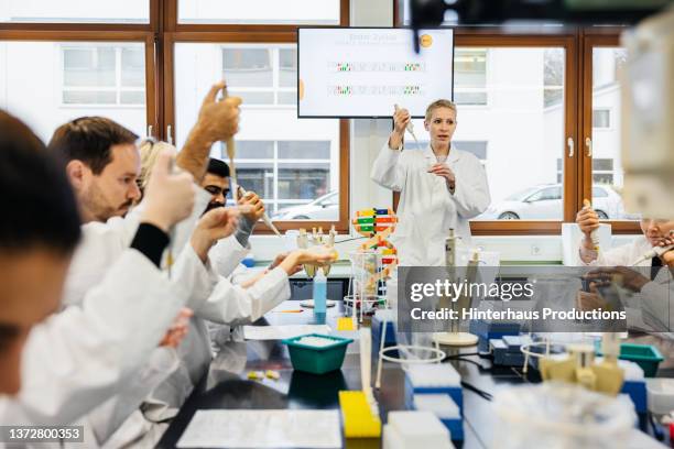 medical lesson with tutor and students performing dna experiment - indian education health science and technology stockfoto's en -beelden