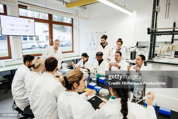 group of students working on dna experiment in laboratory - bulk test stock pictures, royalty-free photos & images