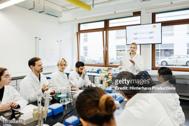 students listening to tutor during medical class in laboratory - men and women in a large group listening stock pictures, royalty-free photos & images
