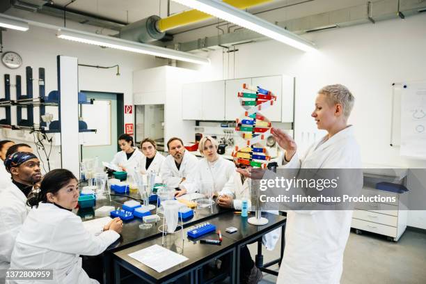 lesson on dna taking place in medical laboratory - men and women in a large group listening stock pictures, royalty-free photos & images