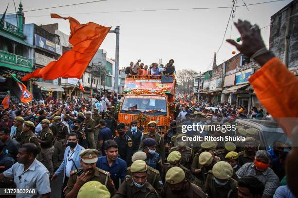 Uttar Pradesh's Chief Minister and Bharatiya Janata Party candidate Yogi Adityanath waves to supporters from atop a truck during a roadshow during...