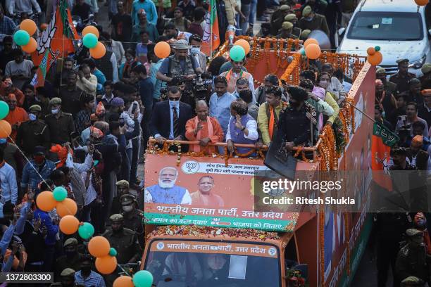 Uttar Pradesh's Chief Minister and Bharatiya Janata Party candidate Yogi Adityanath waves to supporters from atop a truck during a roadshow during...
