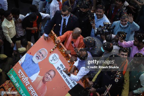 Uttar Pradesh's Chief Minister and Bharatiya Janata Party candidate Yogi Adityanath waves to supporters from atop a truck during a roadshow during...