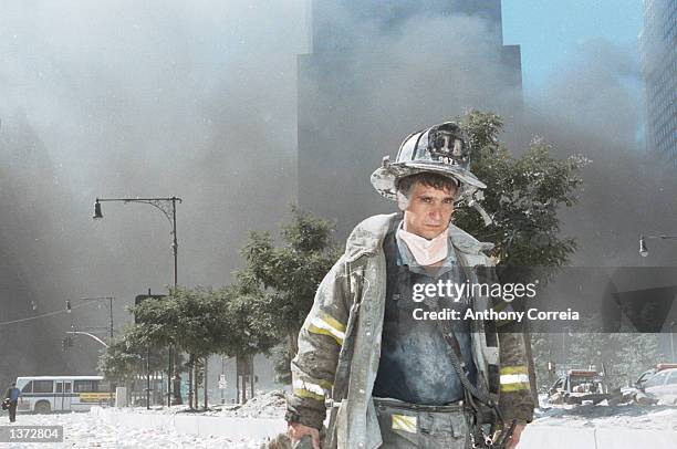 An unidentified New York City firefighter walks away from Ground Zero after the collapse of the Twin Towers September 11, 2001 in New York City. The...