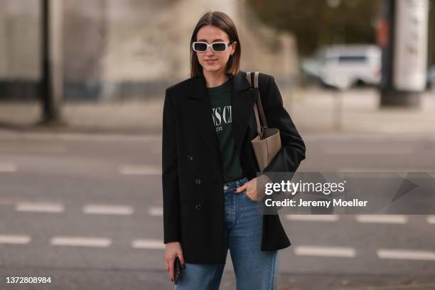 Marie Danker is wearing a JJXX blue skinny denim and green shirt, Adidas white low sneaker, Saint Laurent brown tote bag, Carolina Lemke white and...