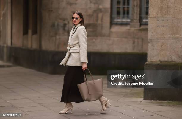 Marie Danker is wearing Ilio Smeraldo beige heels, LeGer brown pleated dress, & other stories beige coat, Carolina Lemke shades and Saint Laurent...