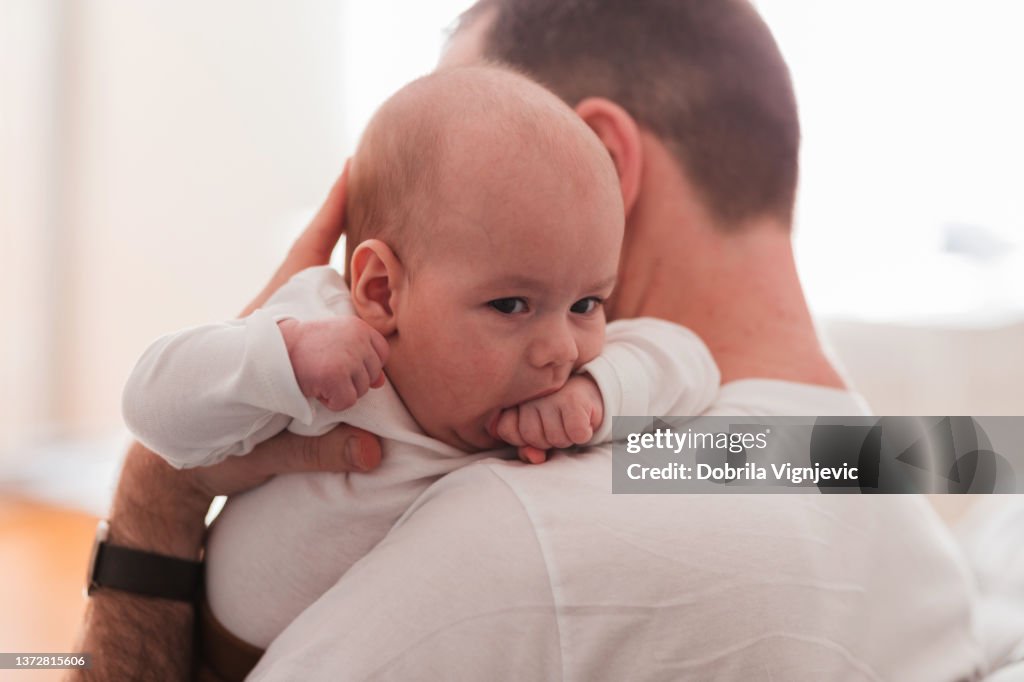 Father holding his baby boy over the shoulder