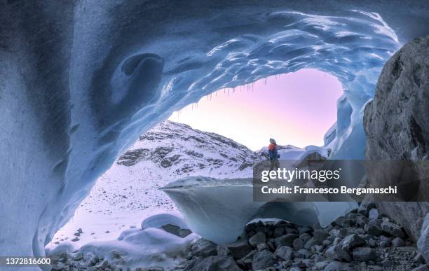 alpinist looks the sunrise from a ice glacier cave. morteratsch glacier, canton of graubunden(grisons), switzerland, europe. - human toe bildbanksfoton och bilder