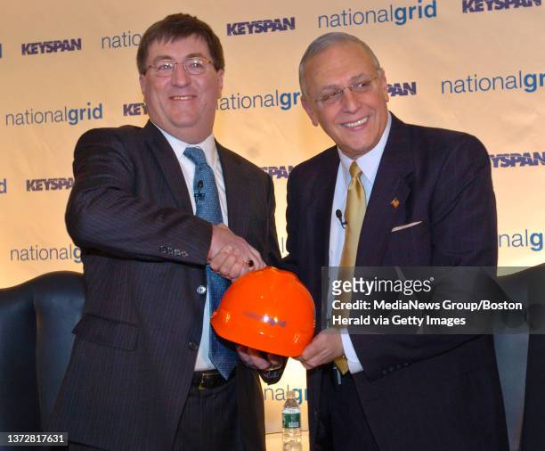 National Grid President and CEO Michael Jesanis and Keyspan Chairman CEO Robert Catell greet during the press conference for the merger of their...