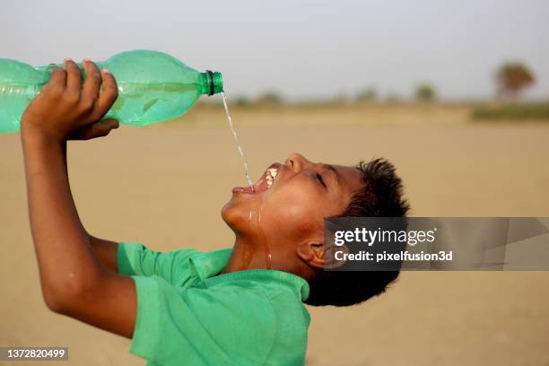 thirsty poor boy drinking water - scarce stock pictures, royalty-free photos & images