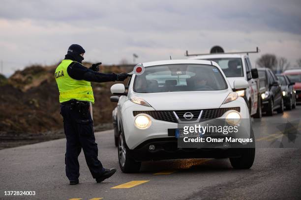 Police officers coordinate traffic as thousands of cars arrive from all over Europe to pick up their relatives at the Polish Ukrainian border on...