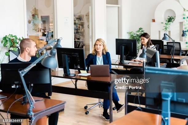 business professionals working at their desks in open plan office - boss over shoulder stock pictures, royalty-free photos & images