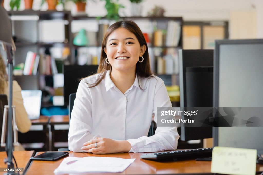 Ritratto di una donna d'affari asiatica fiduciosa alla sua scrivania