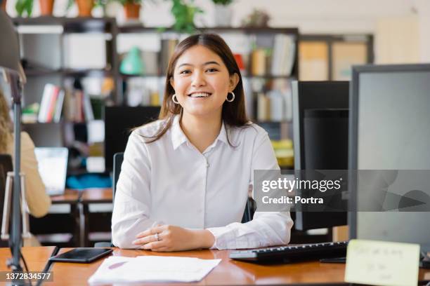 portrait of a confident asian businesswoman at her desk - beautiful filipino women stock pictures, royalty-free photos & images