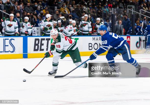 Dmitry Kulikov of the Minnesota Wild skates against Michael Bunting of the Toronto Maple Leafs during the third period at the Scotiabank Arena on...
