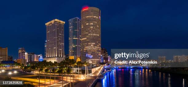 aerial view of the illuminated downtown tampa skyline over the hillsborough river in the night. extra-large, high-resolution stitched panorama. - skyline stitched composition stock pictures, royalty-free photos & images