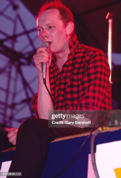 British Rock and Pop musician Joe Jackson sits on the edge of the stage as he performs, during his 'Beat Crazy' tour, as part of the Dr Pepper Summer...