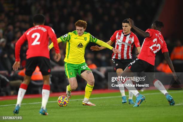 Josh Sargent of Norwich City is challenged by Kyle Walker-Peters, Mohammed Salisu and Mohamed Elyounoussi of Southampton during the Premier League...