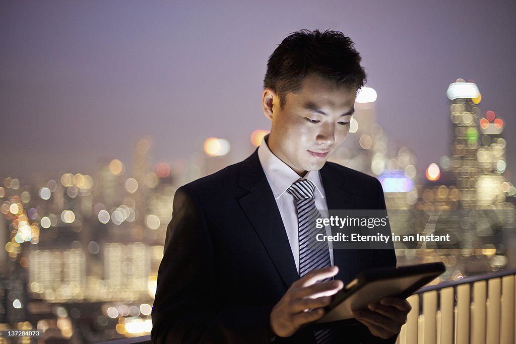 Businessman using digital tablet in city