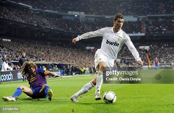 Cristiano Ronaldo of Real Madrid beats Carles Puyol of Barcelona during the Copa del Rey Quarter Finals match between Real Madrid and Barcelona at...