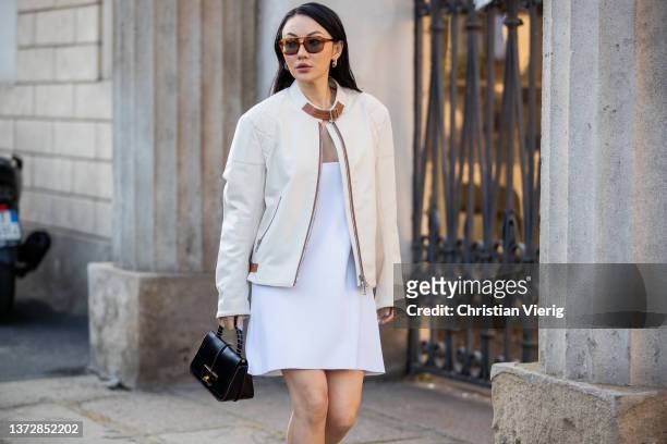 Jessica Wang seen wearing white dress, creme white jacket, brown ankle boots, black bag outside Tod's fashion show during the Milan Fashion Week...