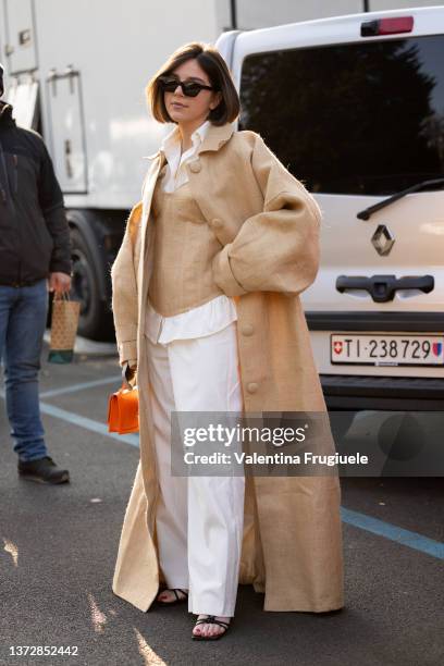 Guest poses ahead of the Tod's fashion show wearing a yuta coat and top during the Milan Fashion Week Fall/Winter 2022/2023 on February 25, 2022 in...