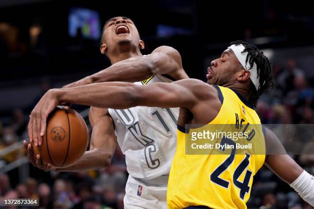 Buddy Hield of the Indiana Pacers blocks a shot attempt by Theo Maledon of the Oklahoma City Thunder in the second quarter at Gainbridge Fieldhouse...