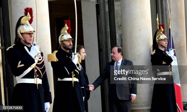 French President Emmanuel Macron escorts Former French President Francois Hollande after their meeting to discuss the Ukraine issue at the Elysee...