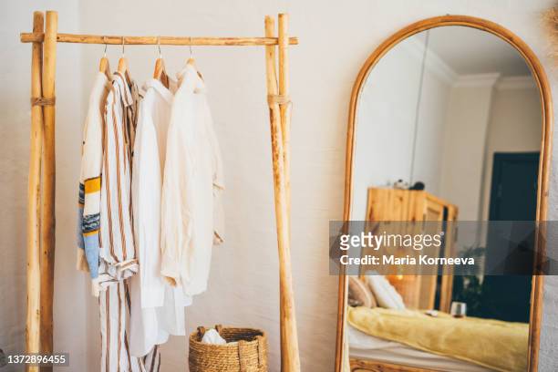 clothes hanging on a hangers near a mirror at  home. - shabby chic stockfoto's en -beelden