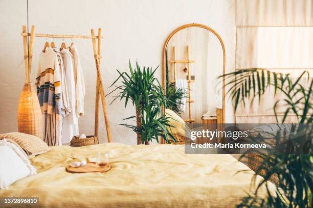 clothes hanging on a hangers near a mirror at  home. - bedroom mirror stock-fotos und bilder