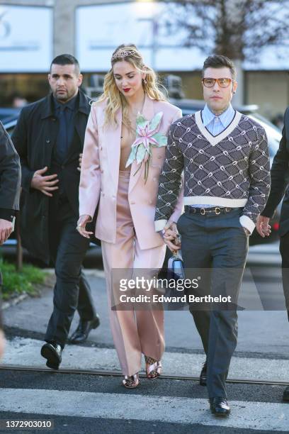 Chiara Ferragni wears a gold and diamond headband / tiara from Gucci, a pale pink satin oversized blazer jacket with a large green and pink...