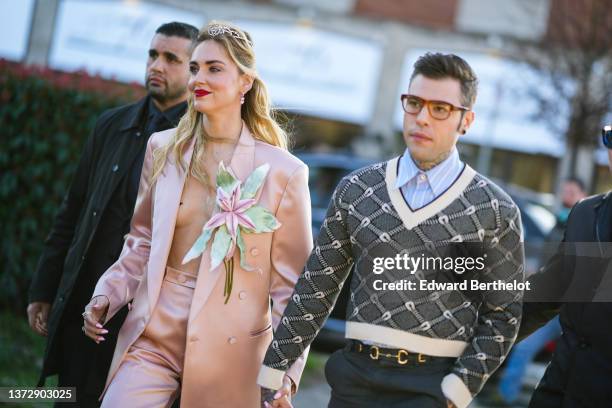 Chiara Ferragni wears a gold and diamond headband / tiara from Gucci, a pale pink satin oversized blazer jacket with a large green and pink...