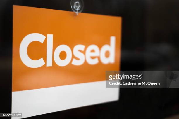 closed sign hanging on front window of retail establishment - paycheck protection program fotografías e imágenes de stock