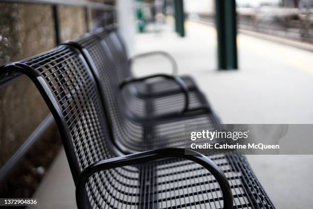 side profile of empty metal bench on commuter train outdoor platform - railroad conductor stock pictures, royalty-free photos & images