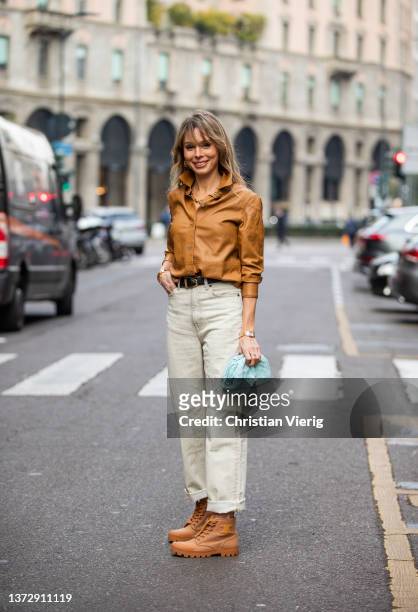 Ekaterina Mamaeva is seen wearing brown shirt Theory, black belt Khaite, beige jeans Acne Studios, brown laced boots Celine, blue bag Bottega Veneta,...