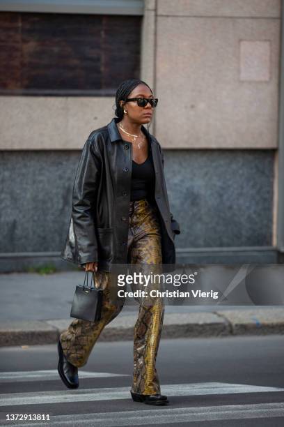 Guest is seen wearing pants with snake print, black leather blazer, bag, shoes outside Sportmax fashion show during the Milan Fashion Week...