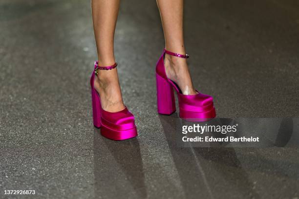 Leonie Hanne wears neon pink shiny satin platform high heels shoes from Versace , outside the Versace fashion show, during the Milan Fashion Week...