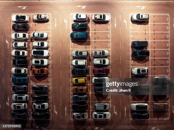 overhead view of cars in parking lot at night - busy park stock pictures, royalty-free photos & images