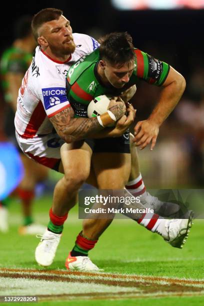 Lachlan Ilias of the Rabbitohs is tackled by Josh McGuire of the Dragons during the Charity Shield NRL Trial Match between the South Sydney Rabbitohs...