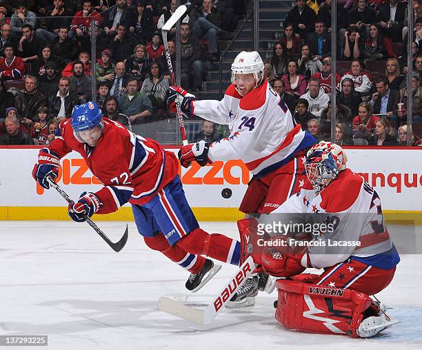 John Carlson of the Washington Capitals pushes Erik Cole of the Montreal Canadiens as goalie Michal Neuvirth stops the puck during the NHL game on...