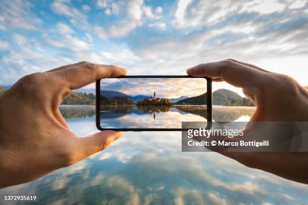 personal perspective of person taking picture with smartphone in bled, slovenia - visor digital imagens e fotografias de stock