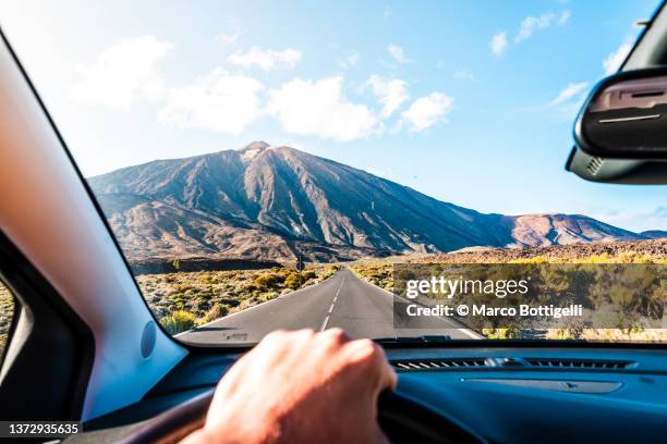 personal perspective of person driving car towards teide volcano, tenerife. - road trip 個照片及圖片檔