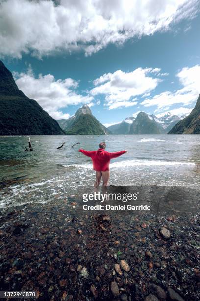 lonely girl enjoying nature in milford sound, new zealand, girl enjoying, living life, happiness - nueva zelanda stock pictures, royalty-free photos & images
