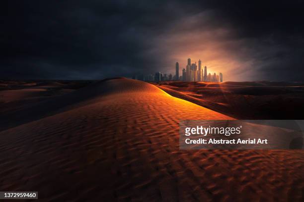 digitally generated image showing the arabian desert and dubai skyline at sunset, united arab emirates - dubai sunset desert stock pictures, royalty-free photos & images