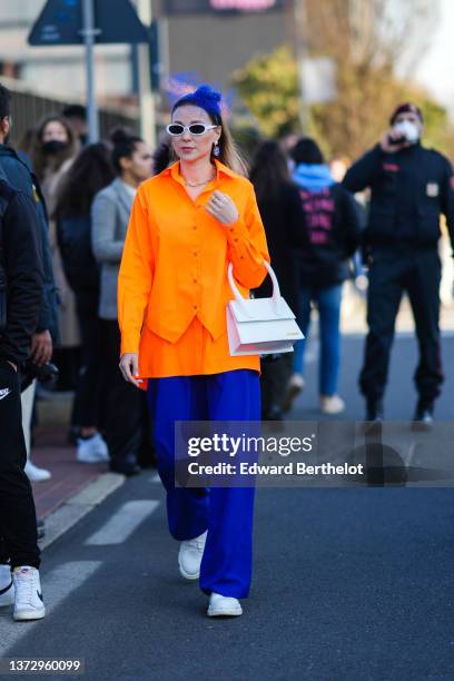 Guest wears a royal blue electric tulle mesh headband, white sunglasses, a pearls and blue stones eyes pattern pendant earrings, a gold chain...