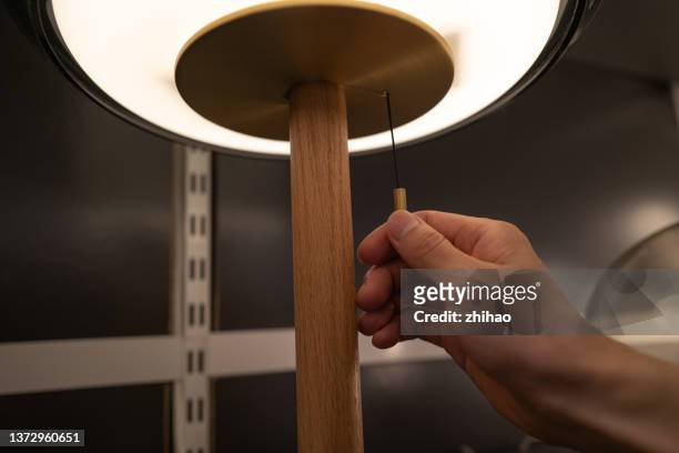 lighting man pulls the switch - lamp imagens e fotografias de stock