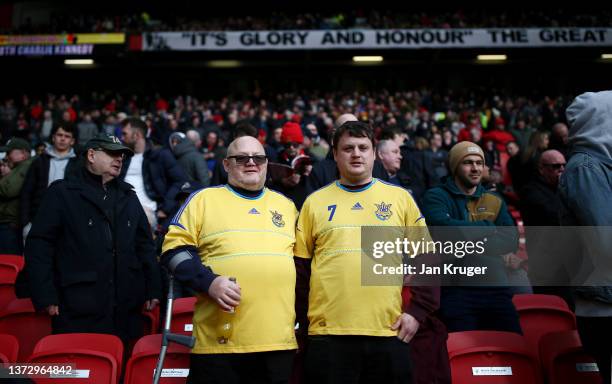 Manchester United fans wear the Ukrainian national shirt to indicate peace and sympathy with Ukraine prior to the Premier League match between...