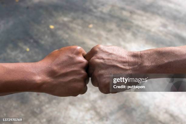 hand-to-hand, mutual respect, fist bump greeting between two men respect each - fistbump stock-fotos und bilder