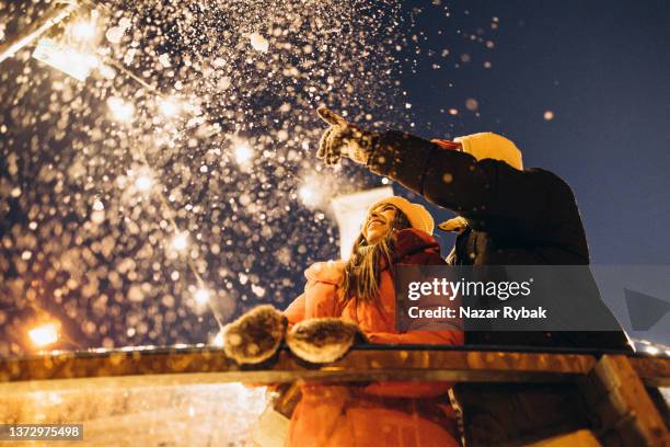 the cheerful couple has a date on the ice rink on christmas eve - couple skating stock pictures, royalty-free photos & images