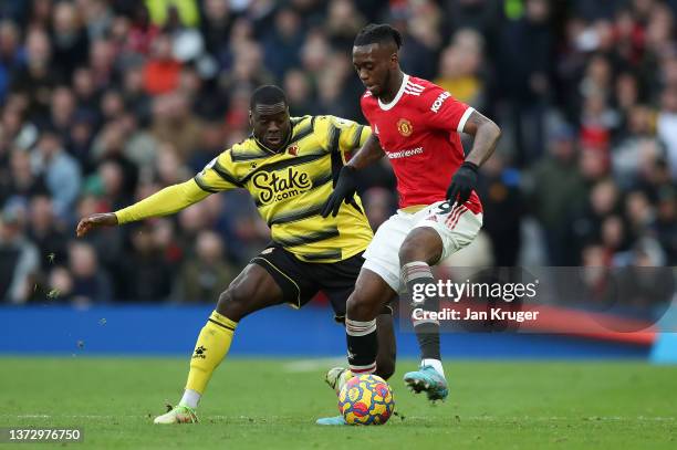 Ken Sema of Watford FC is challenged by Aaron Wan-Bissaka of Manchester United during the Premier League match between Manchester United and Watford...